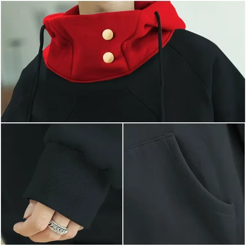 Black coat with red collar and gold buttons, held by a person wearing a ring.