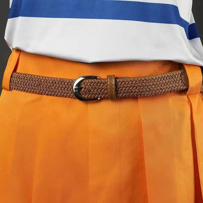 A close-up of a brown braided belt with a silver buckle worn over bright orange pleated trousers, with a white and blue striped shirt partially visible at the top.