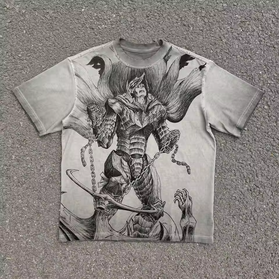 A light gray short-sleeve t-shirt with a large black and white graphic print of a fantasy warrior character, laid flat on a gray asphalt surface.