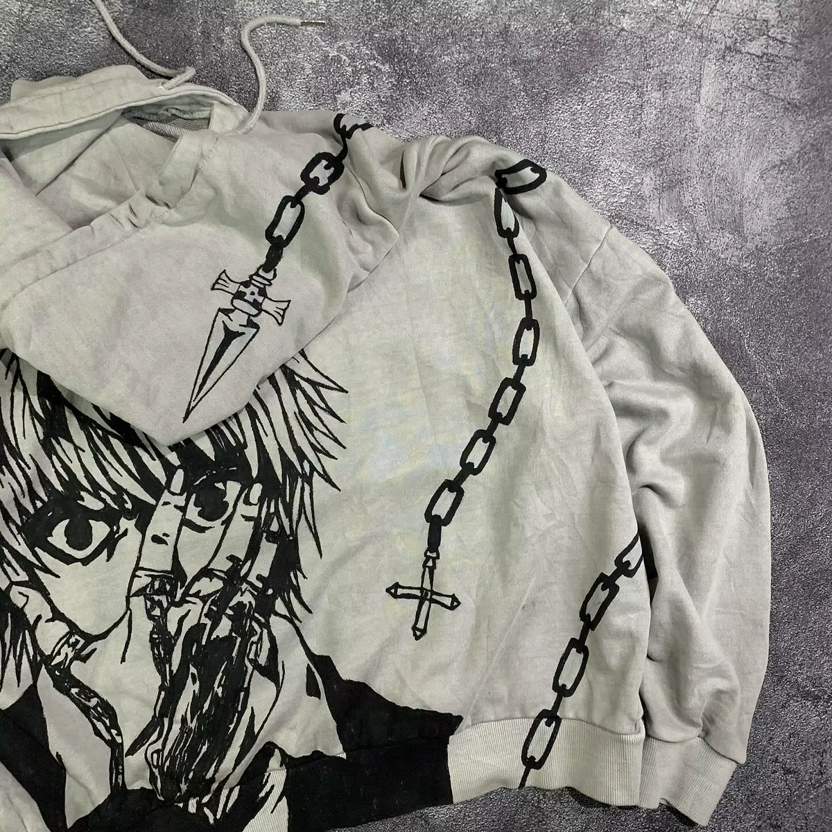Close-up of the Kurapika judgment blade and chain graphic printed directly onto the hood of a Skaiiy pullover.