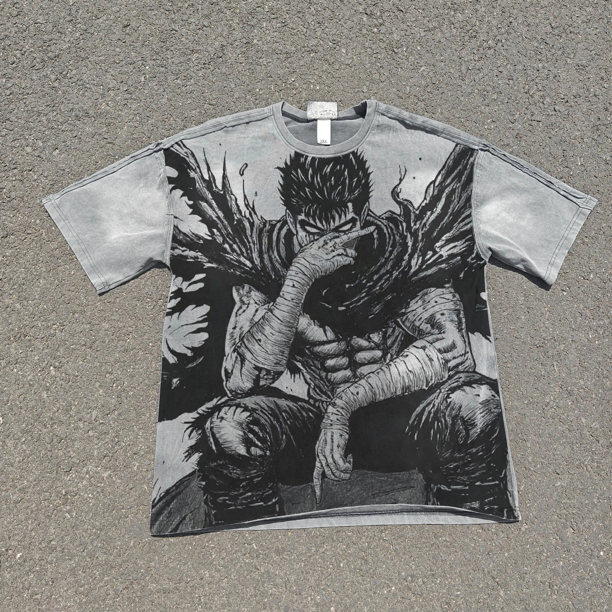T-shirt with a graphic design of a character sitting on the ground, covering their face, on a textured surface.