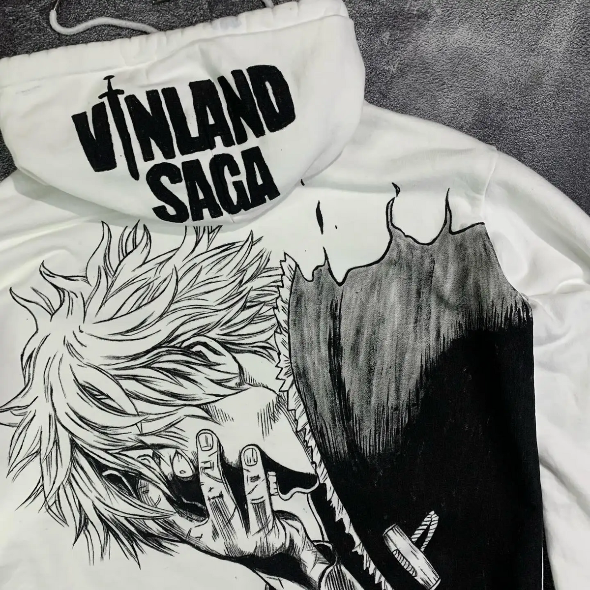 Angled close-up of the high-contrast black ink Thorfinn graphic on a premium white cotton Skaiiy hoodie.